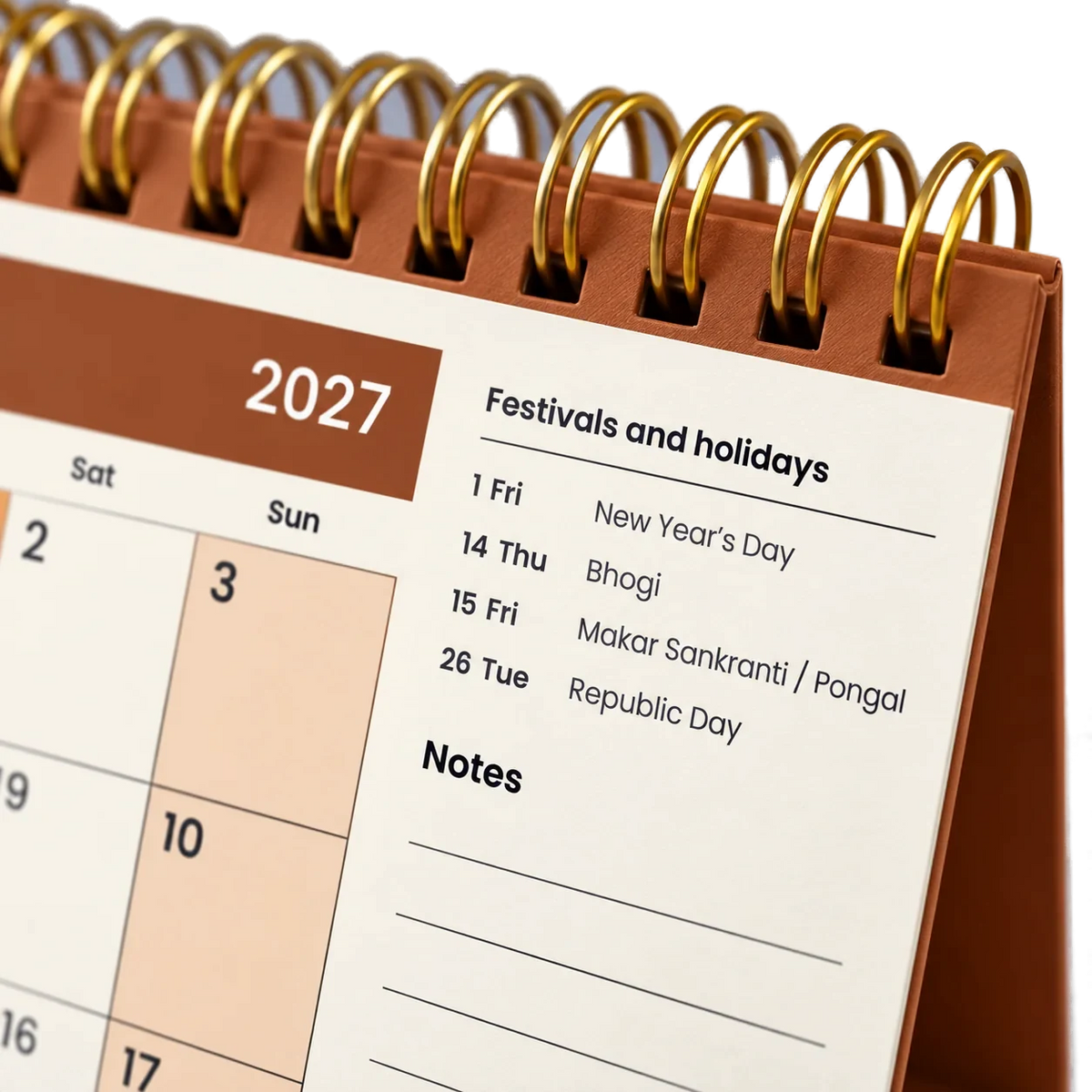 2027 desk calendar in Copper Brown, close-up of the gold wire-o binding, punched holes and festival list
