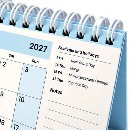 2027 desk calendar in Powder Blue, close-up of the white wire-o binding, punched holes and festival list