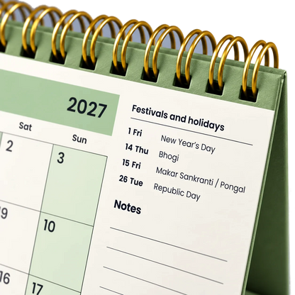 2027 desk calendar in Sage Green, close-up of the gold wire-o binding, punched holes and festival list